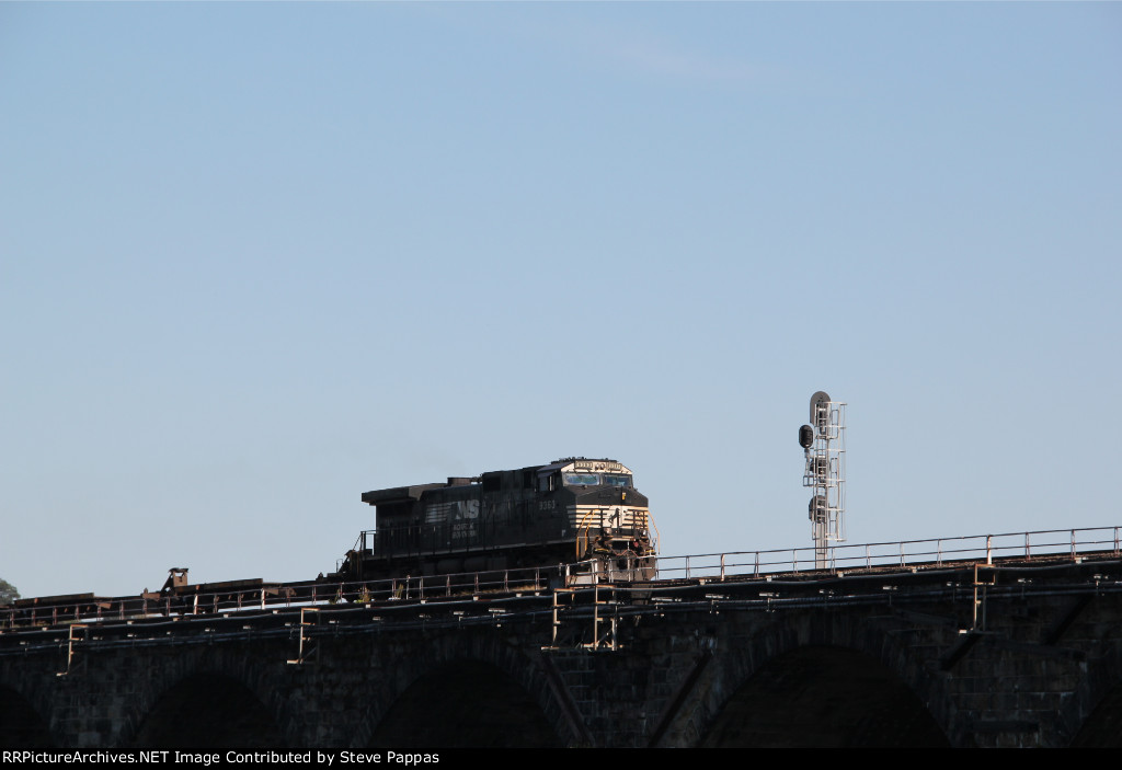 NS 9363 takes a string of flat cars west over Rockville bridge